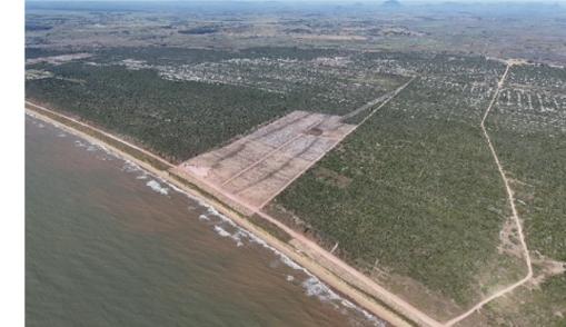 Visão aérea ampla mostrando o canteiro de obras do terminal Tegran Kennedy próximo ao mar